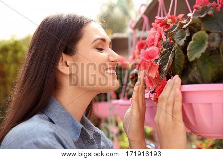 Pretty young woman with begonia flowers, close up view