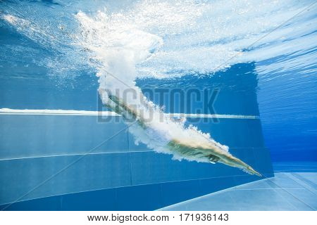 a young man is jumping into the water from a diving plattform