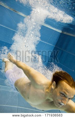 a young man is jumping into the water from a diving plattform