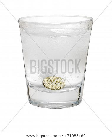 Pound coin like alka seltzer dissolving in glass isolated on white