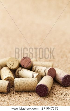 Corks From Wine Bottles Lie In A Pile On A Wooden Background. Natural Fon With Heap Of Corks From Re