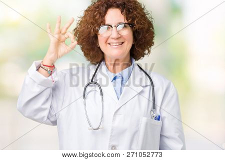 Middle ager senior doctor woman over isolated background smiling positive doing ok sign with hand and fingers. Successful expression.