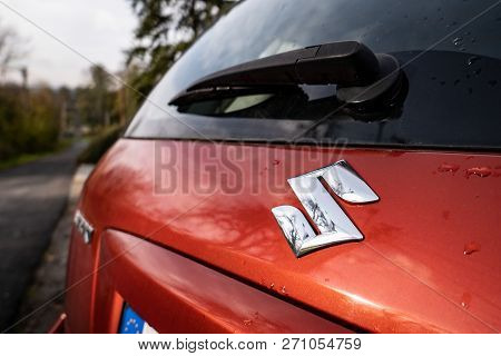 Senov, Czech Republic - Octobe 23, 2018: Logo Of Suzuki Automotive Company On A Dark Red Small Suv S