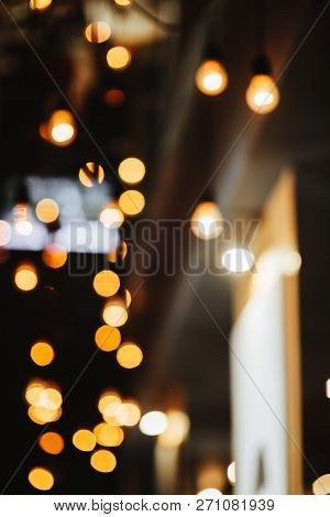 Burning Bulb Shines Weakly On The Background Blurred Yellow Lights
