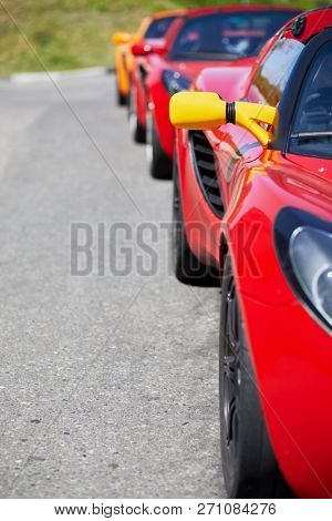 MOSCOW, RUSSIA - MAY 27, 2018: Column of several red Lotus cars stand in line near multilane highway.