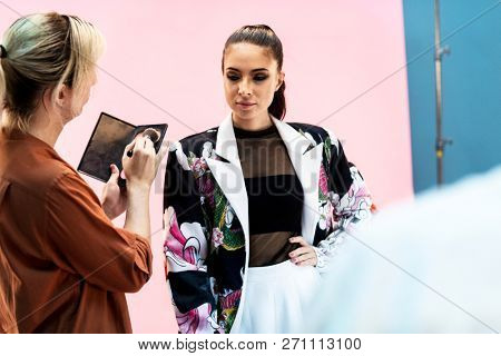Makeup artist doing touch ups for the model