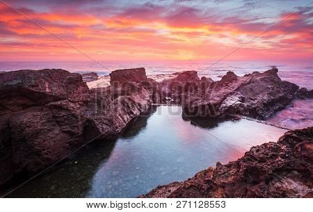 Blazing Red Sunrise Scorching The Skies Over Beautiful Rock Pool With Stoney Bottom And Surrounded B