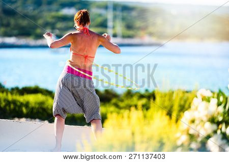 Attractive Adult Woman Is Playing With Hula Hoop In Nature.