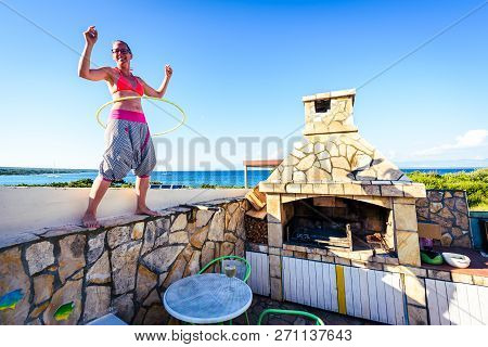 Attractive Adult Woman Is Playing With Hula Hoop In Nature.