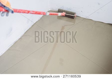 Plasterer During Floor Covering Works With Self-levelling Cement Mortar