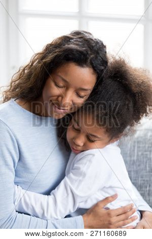 Loving African American Mother Embracing With Daughter