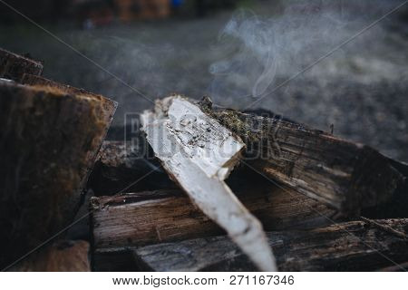 Bonfire In The Grill. Punctured Firewood Lies In A Fire In A Metal Forged Brazier. Fire And Smoke Ar