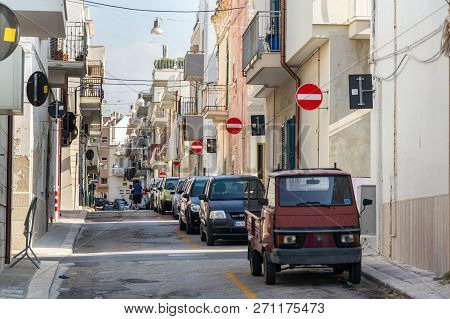 Polignano A Mare, Italy - July 6 2018: People Walk Along Parked Cars On Street With Many No Entry Tr