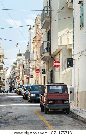 Polignano A Mare, Italy - July 6 2018: People Walk Along Parked Cars On Street With Many No Entry Tr