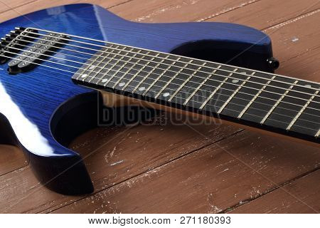Musical Instrument - Fragment 8-string Blue Electric Guitar Solid-body On A Wood Background