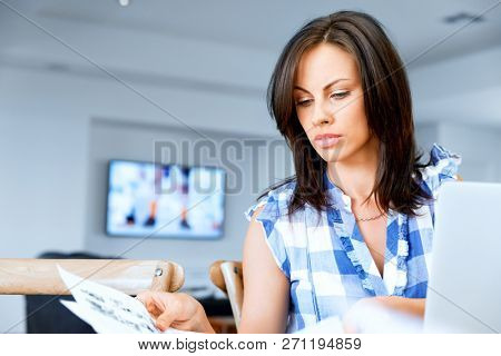 Woman with papers in their living room