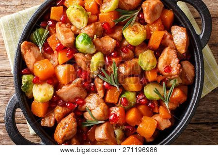 Chicken Stew With Sweet Potatoes, Brussels Sprouts In Pomegranate Sauce Close-up In A Pan On The Tab
