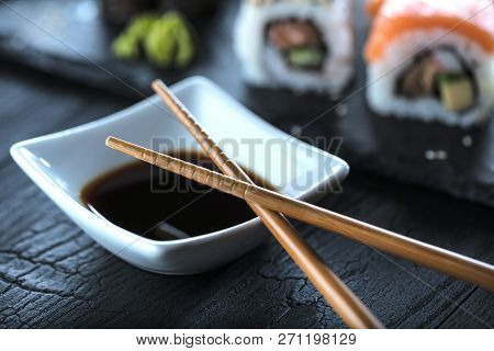 Sushi Set Sashimi And Sushi Rolls Served On Stone Slate.