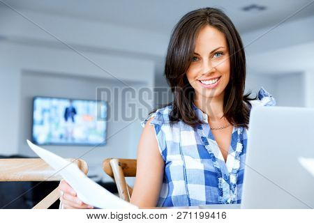 Woman with papers in their living room