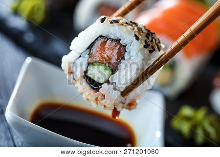 Sushi Set Sashimi And Sushi Rolls Served On Stone Slate.