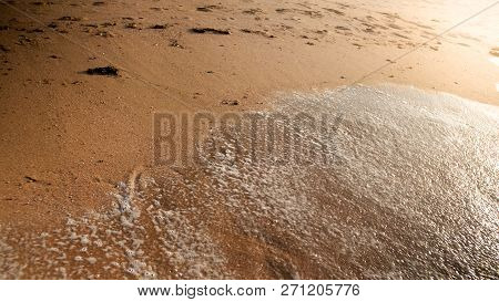Closeup Photo Of Wet Sand And Footrpints On The Sea Beach At Sunsent
