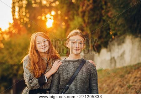 Outdoor Sunset Portrait Of Two Young Preteen Girls
