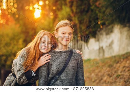Outdoor Sunset Portrait Of Two Young Preteen Girls