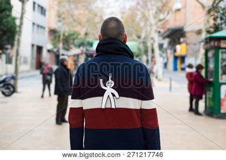 young man in the street with a paper man in his back as a prank for the dia de los inocentes, the innocents day, a feast held in spain, hispanic america and philippines equivalent to april fools day