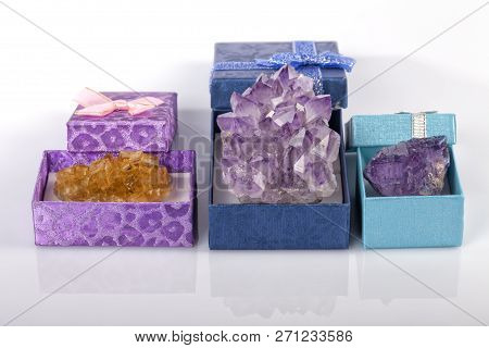 Three boxes with two fluorite stones and one Amethyst isolated on white background.