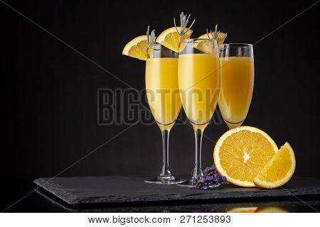 Mimosa Cocktails In Champagne Glasses With Orange Juice And Sparkling Wine Decorated With Lavender L
