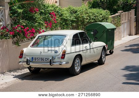 Santa Ponsa, Mallorca, Spain - July 24, 2013:  Retro Car Mg Bgt Is Parked Near A Wall With Flowers A