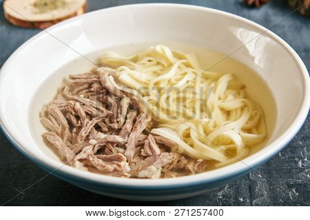 Kespe Soup, Kullama or Beshbarmak is National Central Asia Dish with a Rich Broth, Tender Veal and Homemade Noodles. Clear Bouillon with Finely Chopped Boiled Meat and Spiced Onion Sauce