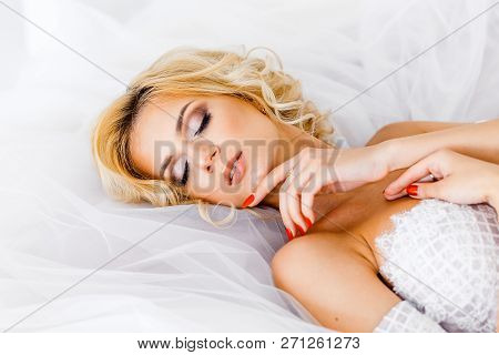 A Bride With Hairstyle And Make Up Lying On Her Dress. A Portrait Of Beautiful Girl Lying On Fatin C