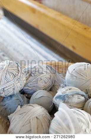 Closeup Of Basket Full Of A Blue, White And Brown Ball Of Matte Crumble. A Loom In The Background