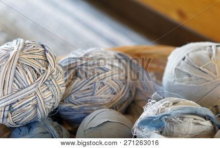Closeup Of Basket Full Of A Blue, White And Brown Ball Of Matte Crumble. A Loom In The Background