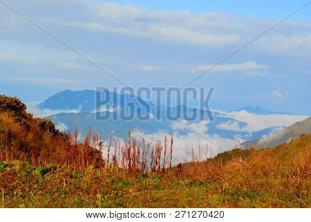 Landscape - View From The Mountain Pass On A Sunny Day To The Valley Hidden By Low Clouds