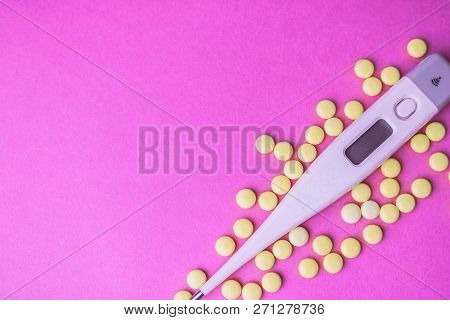 Small Medical Pharmacetic Round Pills, Vitamins, Drugs And Electronic Digital Thermometer On A Pink 