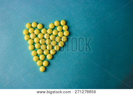 Small Medical Pharmaceptic Round Yellow Pills, Vitamins, Drugs, Antibiotics In The Form Of A Heart O
