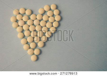 Small Medical Pharmaceptic Round Yellow Pills, Vitamins, Drugs, Antibiotics In The Form Of A Heart O