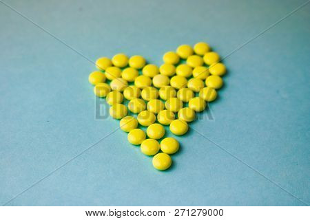 Small Medical Pharmaceptic Round Yellow Pills, Vitamins, Drugs, Antibiotics In The Form Of A Heart O
