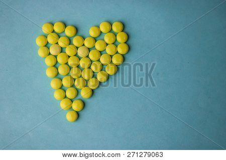 Small Medical Pharmaceptic Round Yellow Pills, Vitamins, Drugs, Antibiotics In The Form Of A Heart O