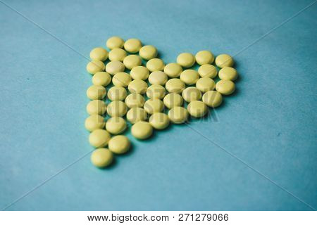 Small Medical Pharmaceptic Round Yellow Pills, Vitamins, Drugs, Antibiotics In The Form Of A Heart O