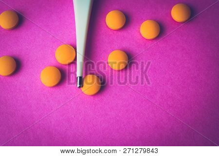 Small Medical Pharmacetic Round Pills, Vitamins, Drugs And Electronic Digital Thermometer On A Pink 