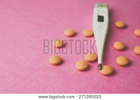 Small Medical Pharmacetic Round Pills, Vitamins, Drugs And Electronic Digital Thermometer On A Pink 