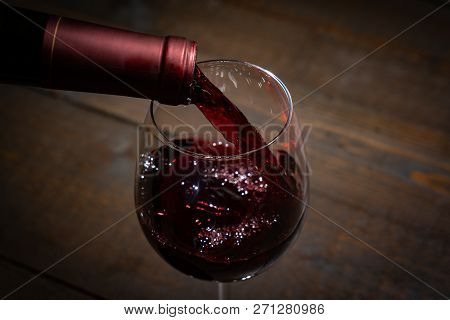 Red Wine Pouring Into A  Wineglass From A Bottel