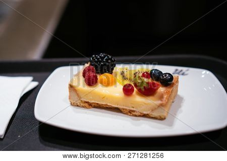 On The Table Is A Plate With Cheesecake.