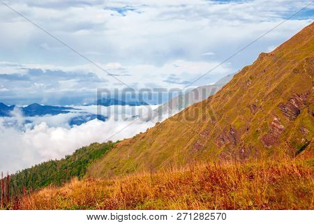 Landscape - View From The Mountain Pass On A Sunny Day To The Valley Hidden By Low Clouds
