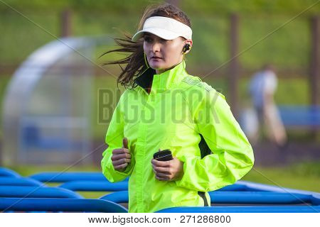 Jogging And Running Concepts. Portrait Of Professional Female Runner During Outdoor Training. Wearin