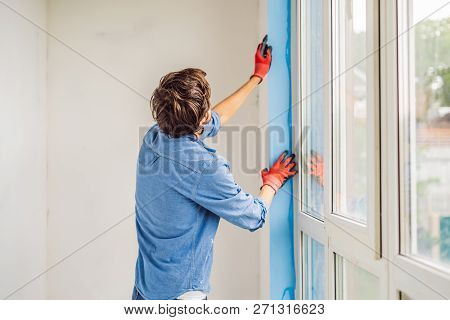 Man In A Blue Shirt Does Window Installation