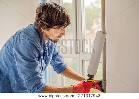 Man In A Blue Shirt Does Window Installation